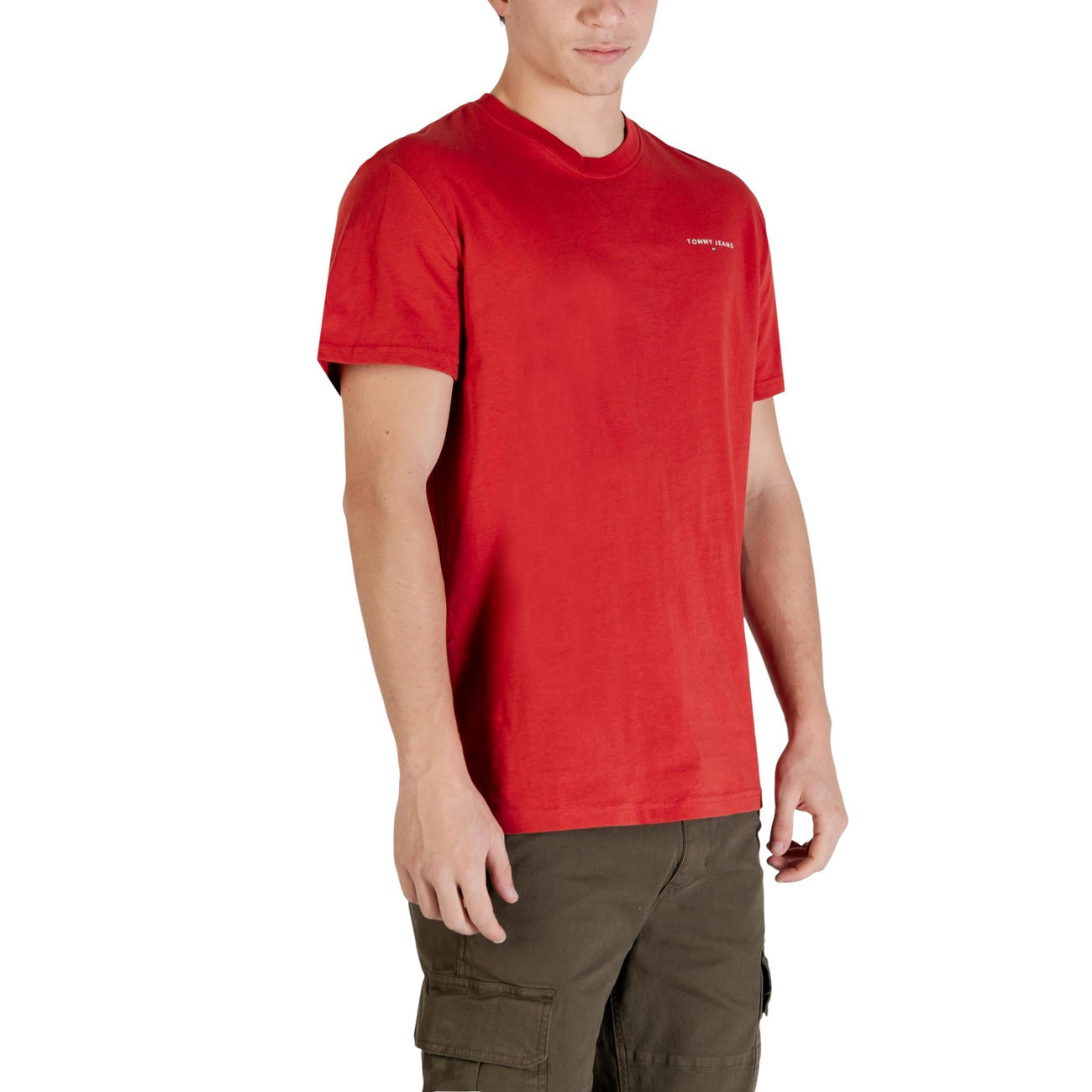 T-shirt Tommy Jeans Slim Linear; 100% Cotone Rigenerato. Taglio slim fit, logo frontale distintivo, maniche corte. Comfort sostenibile per un look casual ricercato. Colore rosso. Vista laterale 
