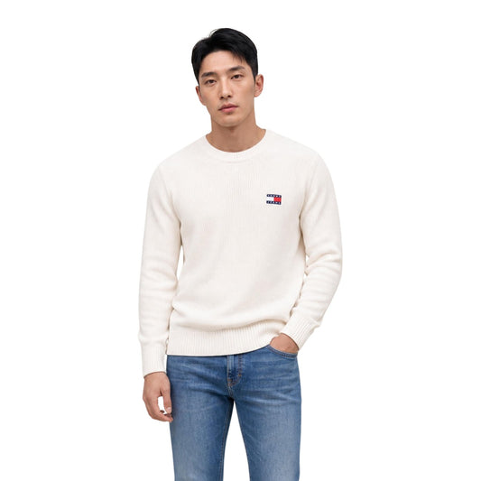 Maglione Tommy Jeans uomo bianco DM0DM20923. Pullover a girocollo in cotone sostenibile con lavorazione a maglia spessa, maniche lunghe, bordi a costine e logo classico applicato sul petto.