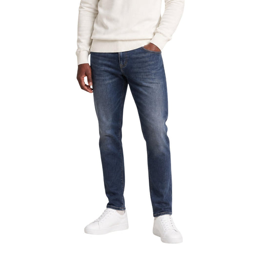 Jeans Slim Blu Uomo Tommy Hilfiger Scanton; Tessuto 99% cotone e 1% elastam. Modello 5 tasche, altezza vita regular con chiusura a cerniera lampo e bottone. Dettagli logo istituzionali, stile casual 4 stagioni. Vista frontale 