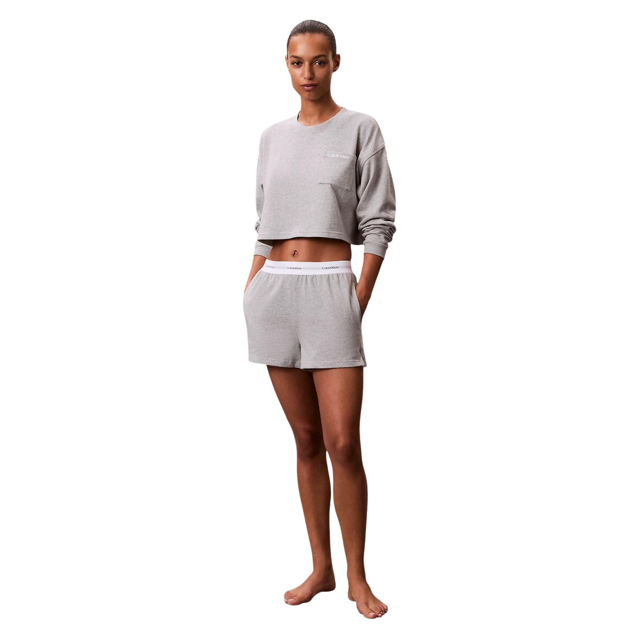 Pantaloncini pigiama Calvin Klein donna grigi. Shorts da notte e loungewear in morbido jersey di cotone a tinta unita con tasche laterali e spacco sull'orlo, caratterizzati dalla classica fascia elastica logata in vita, stile sportivo e minimalista.