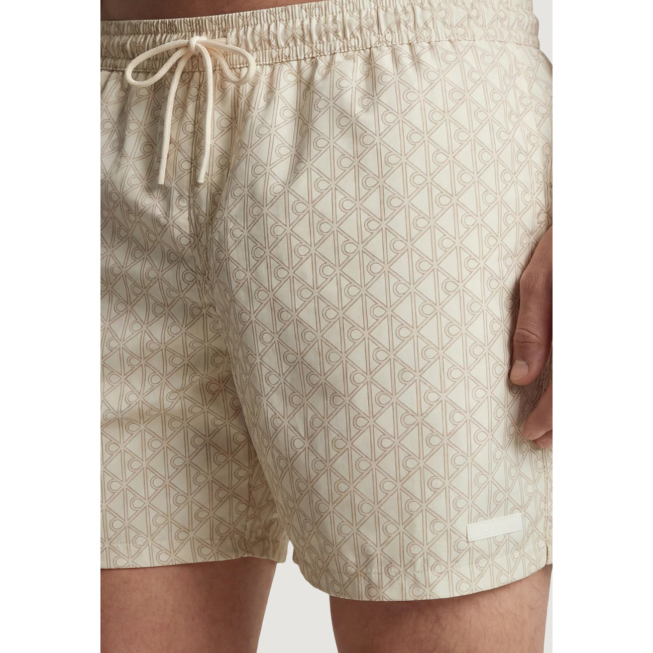 Boxer Mare Calvin Klein; Beige. 100% Poliestere Riciclato. Vita regular con coulisse, lunghezza media, asciugatura rapida. Logo minimal, stile casual e sostenibile. Dettaglio stampa 