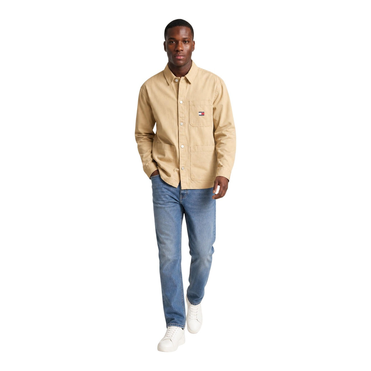 Camicia Beige Tommy Jeans; Utility Style. 100% Cotone Rigenerato. Doppia tasca frontale, logo ricamato, vestibilità regolare. Robusta, versatile e attenta all'ambiente. Figura intera 