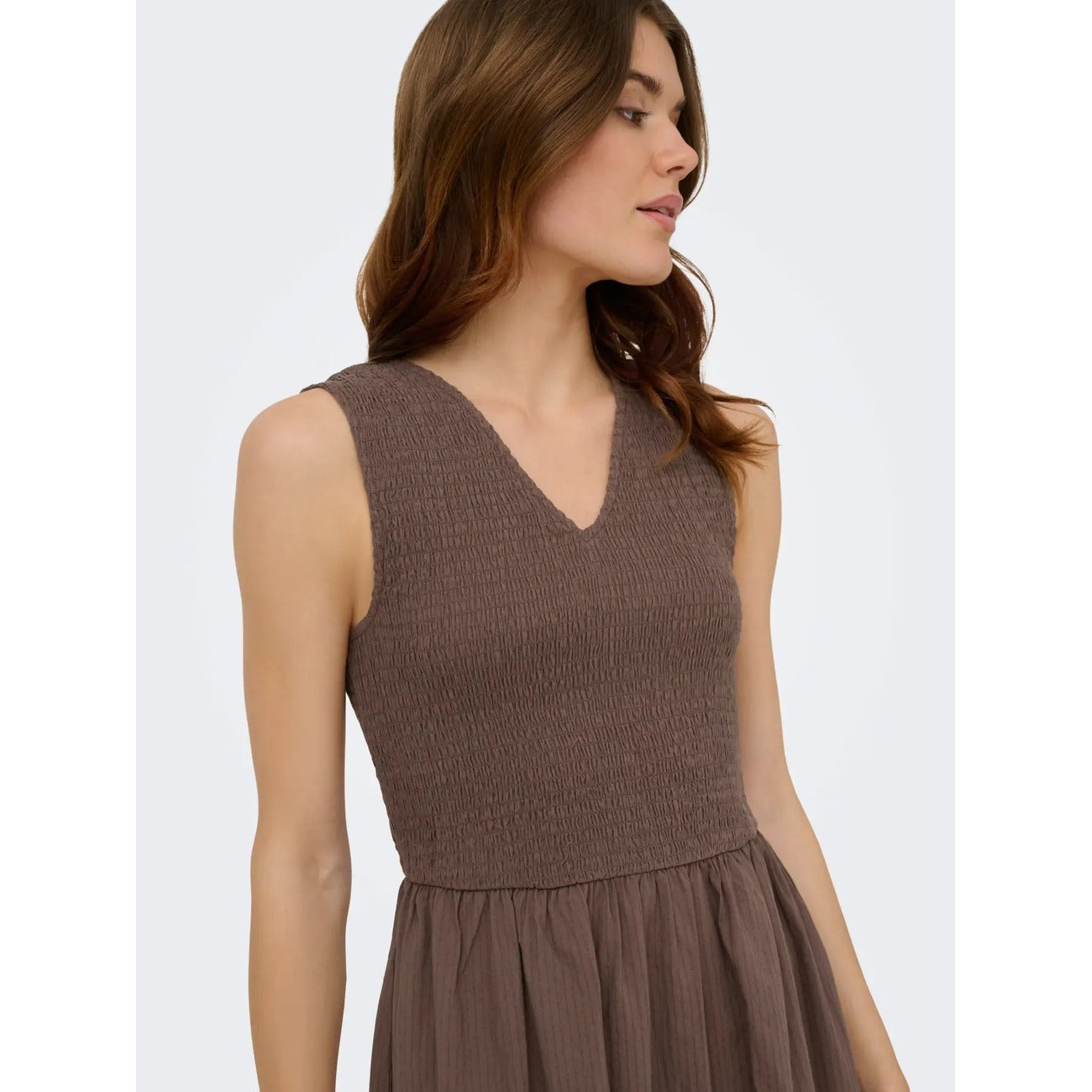 Abito Lungo Donna Marrone Only; Vestito smanicato in cotone tinta unita con scollo a V e dettaglio smock sul busto. Taglio fluido regular fit leggero, stile casual-chic per la primavera e l'estate.