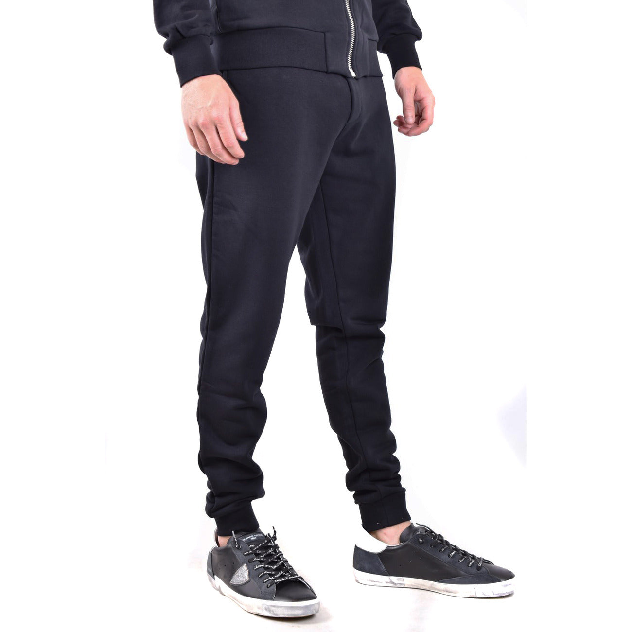 Jogger Philipp Plein; Nero. Felpa di cotone, dettagli in pelle saffiano e nylon, chiusura con coulisse stop-cord. Fondo a costina, vestibilità regular sportiva. Qualità Made in TR. Vista frontale laterale 
