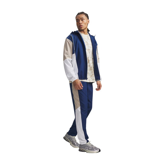 Pantaloni Under Armour uomo blu modello UA RIVAL WOVEN CB PANTS. Pantaloni lunghi da tute sportive e allenamento in poliestere con bande a contrasto colour block, vita elastica e tasche con cerniera, pantalone casual athleisure per la mezza stagione.