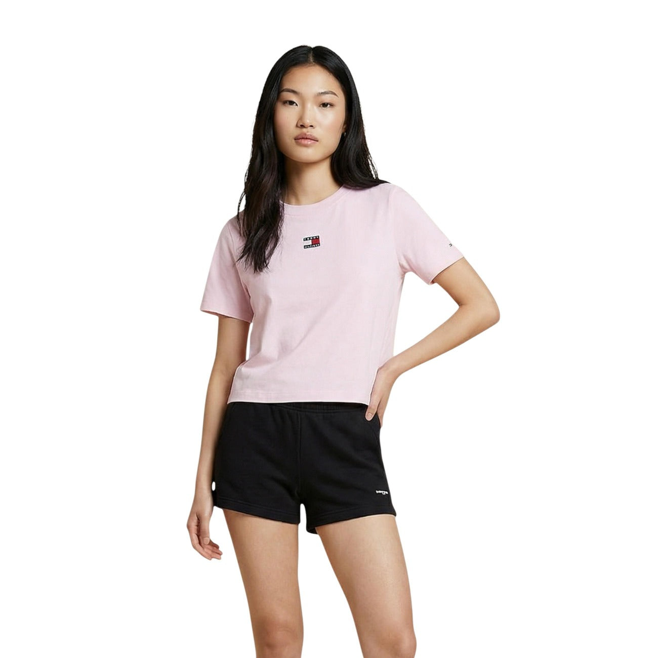 T-shirt Donna Tommy Jeans Boxy Cropped; 100% Cotone. Spalle scese, logo badge sul petto, taglio corto. Maglia donna fresca e di tendenza per la PE26. Colore Rosa chiaro