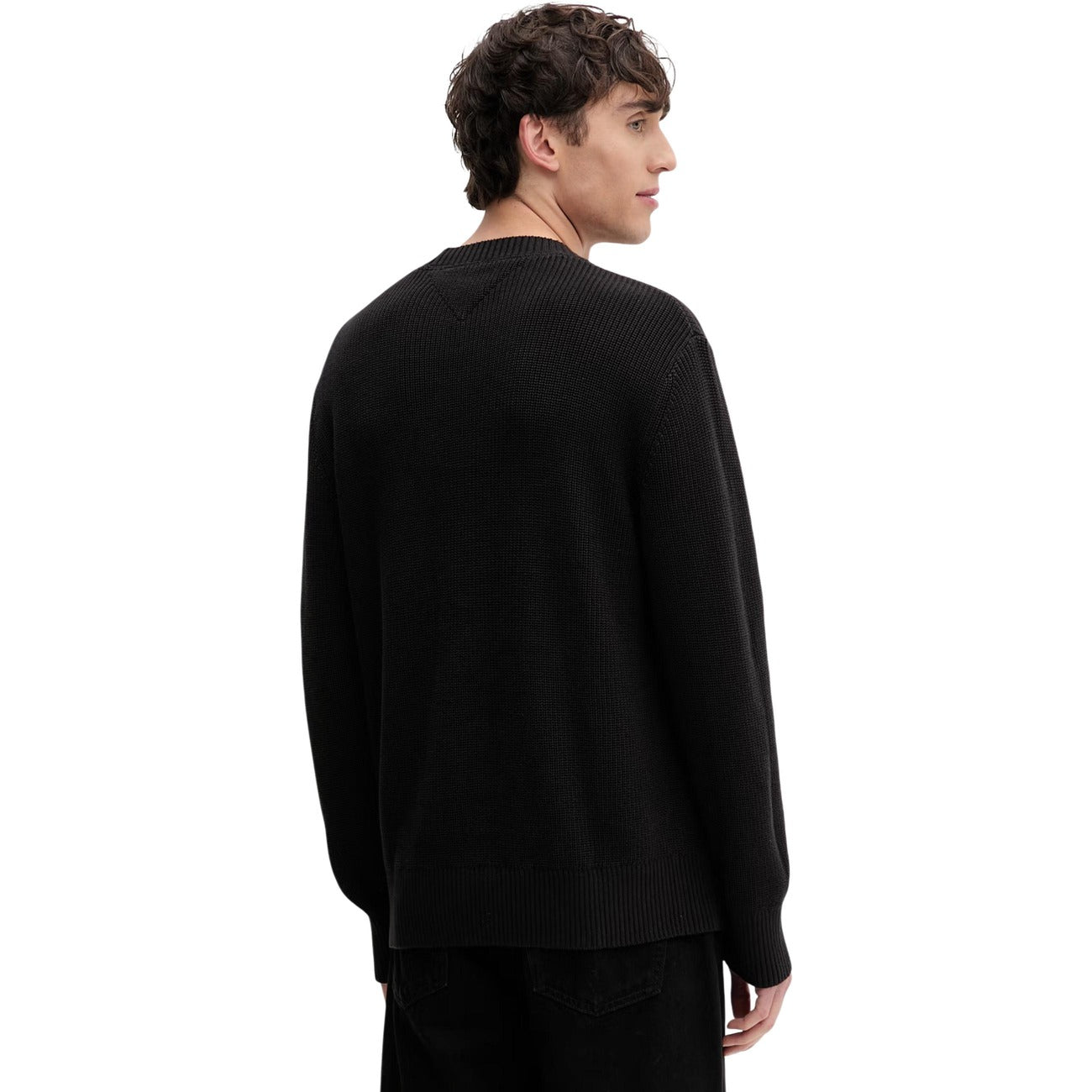 Maglione Tommy Jeans uomo nero DM0DM20923. Pullover a girocollo in cotone sostenibile con lavorazione a maglia spessa, maniche lunghe, bordi a costine e logo classico applicato sul petto.