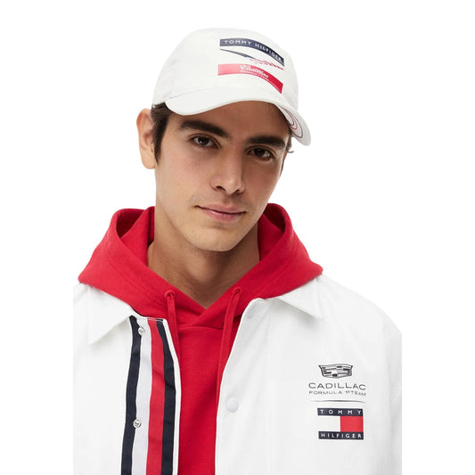 Cappellino bianco uomo Tommy Hilfiger Cadillac Formula 1 AU0AU02091YCF. Cappello da baseball sportivo F1 in tessuto bianco con visiera curva, fori di ventilazione e grafica chevron.