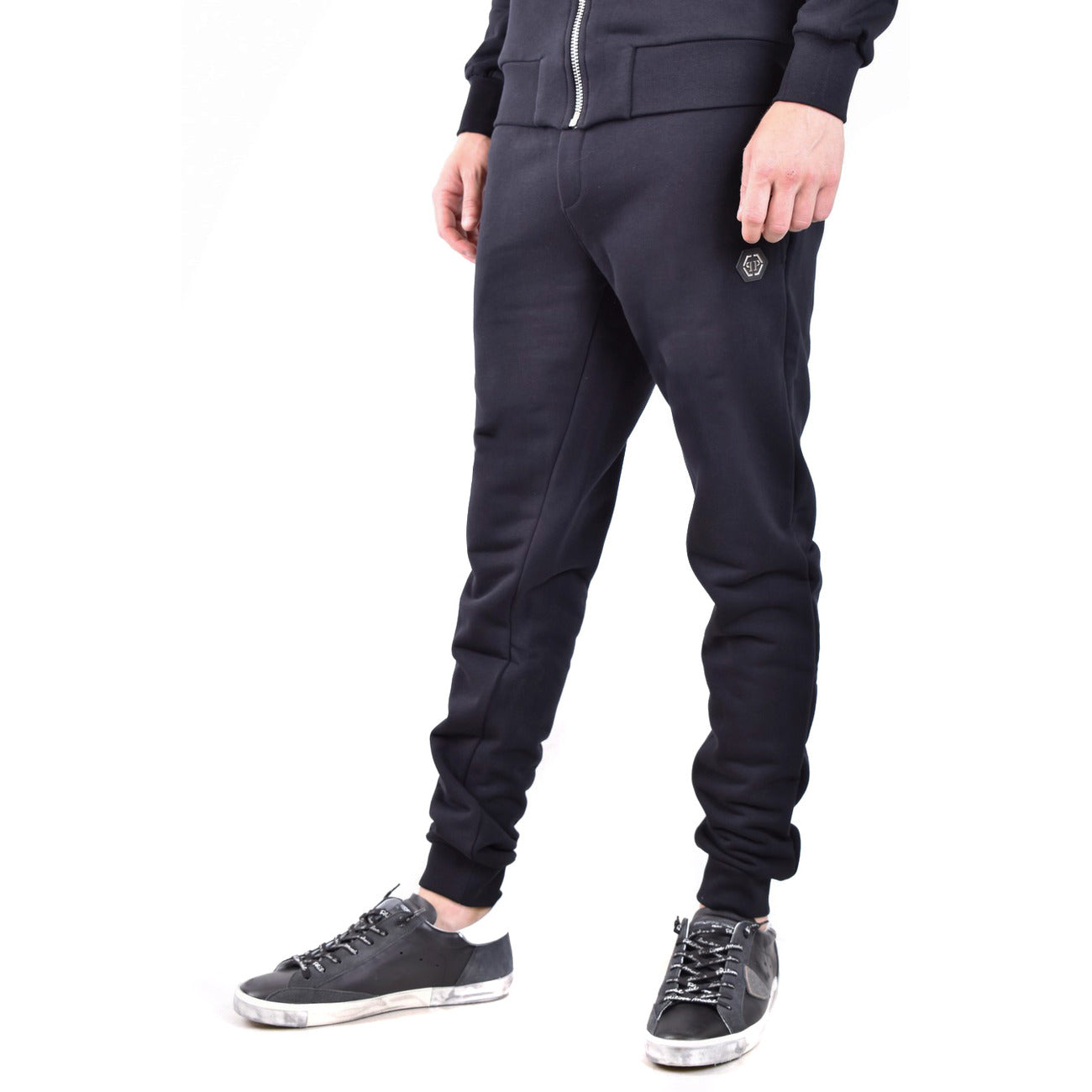 Jogger Philipp Plein; Nero. Felpa di cotone, dettagli in pelle saffiano e nylon, chiusura con coulisse stop-cord. Fondo a costina, vestibilità regular sportiva. Qualità Made in TR. Vista laterale 