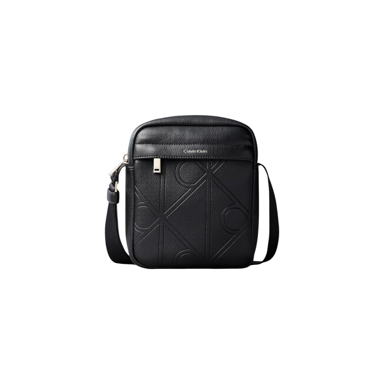 Borsa Tracolla Uomo Calvin Klein Reporter; Nero. 100% Poliuretano effetto pelle martellata con loghi incisi, chiusura zippata, tracolla regolabile. Dimensioni compatte (16x20 cm), stile minimal e moderno 4 stagioni. Vista frontale 