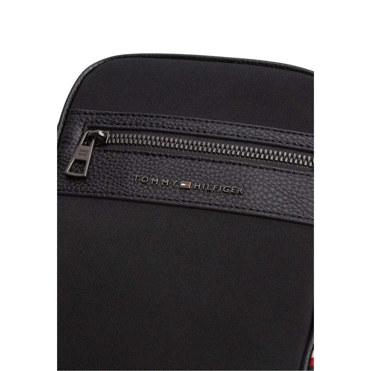 Borsa Tracolla Uomo Tommy Hilfiger Repreve; Nero. 95% Poliestere riciclato REPREVE, doppia cerniera, tracolla regolabile in nastro, dettagli martellati e micro bandierina. Dimensioni mini (15x20,5 cm), stile casual ed eco-friendly. Vista frontale cerniera 