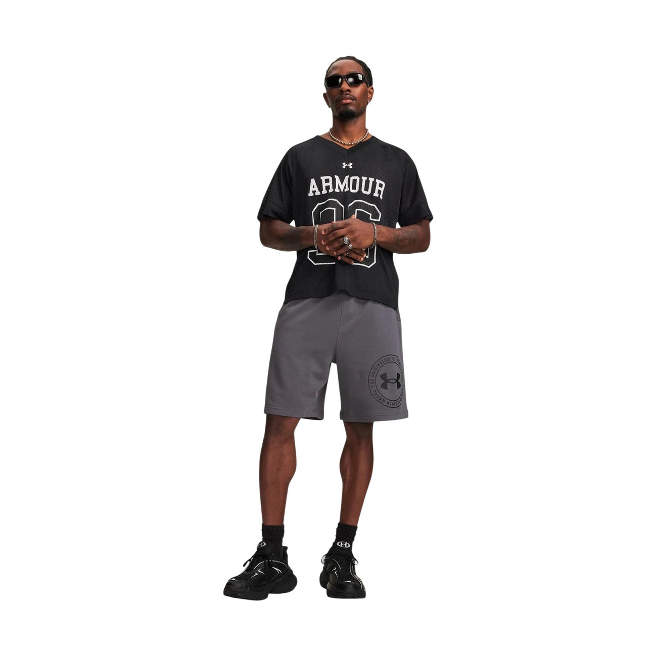 Bermuda Uomo Grigi Under Armour Sportivi; Pantaloncino in spugna leggera misto cotone con stampa logo laterale. Vita elastica, tasche laterali e tasca posteriore, stile activewear e tempo libero. Figura intera 
