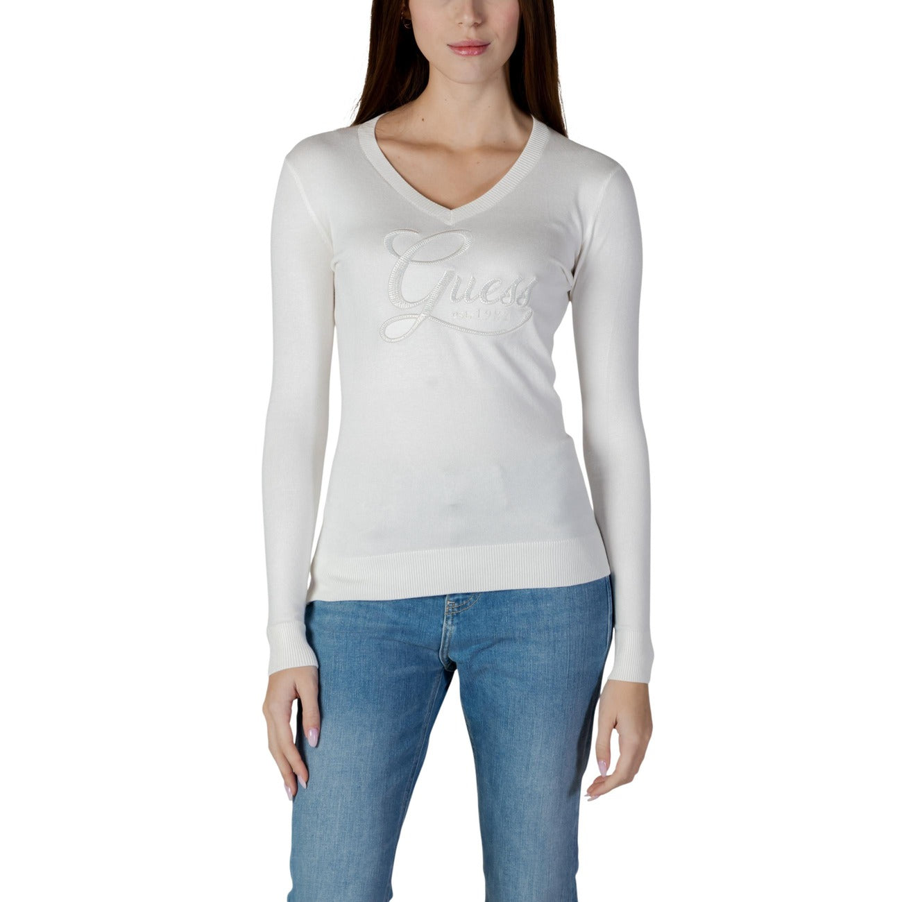 Maglia Guess Stephanie; Bianco. 82% Viscosa, 16% Poliammide, 2% Elastam. Scollo a V, logo gioiello, maniche lunghe. Tessuto fluido e aderente, stile chic quotidiano.Frontale 