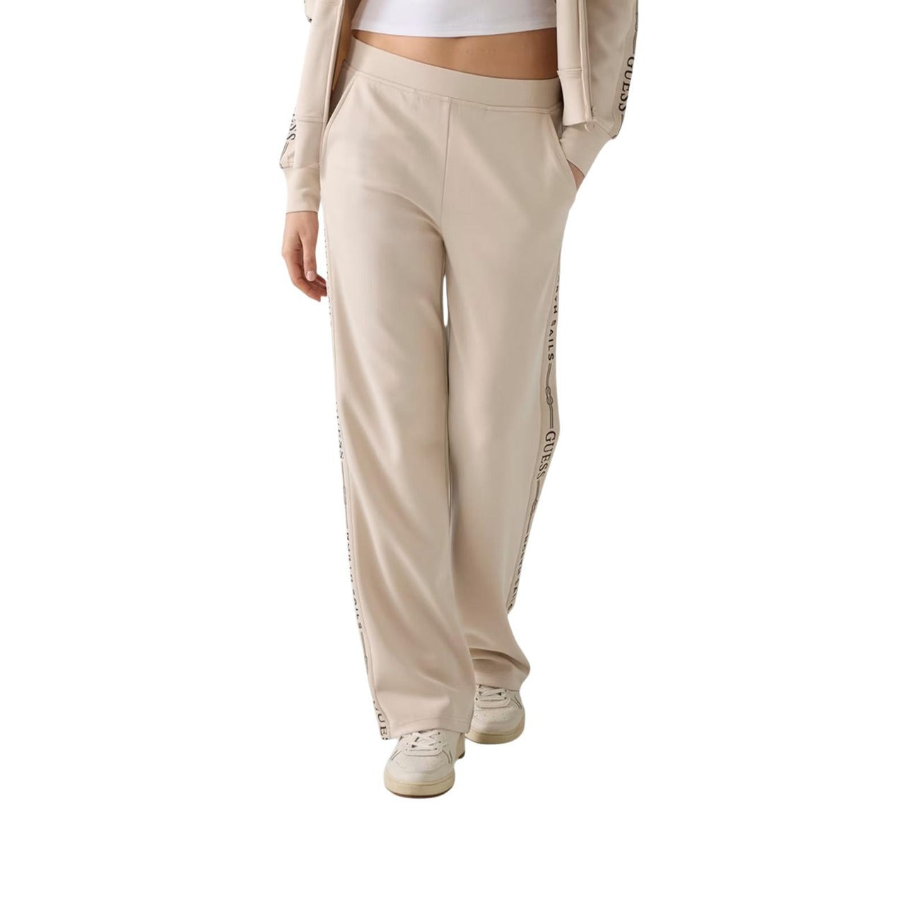 Pantaloni Guess donna beige sportivi W6GB29 K3282. Jogger wide fit morbidi in modal con fascia elastica in vita, tasche e banda con logo Guess sulla gamba, abbigliamento casual e athleisure 4 stagioni.