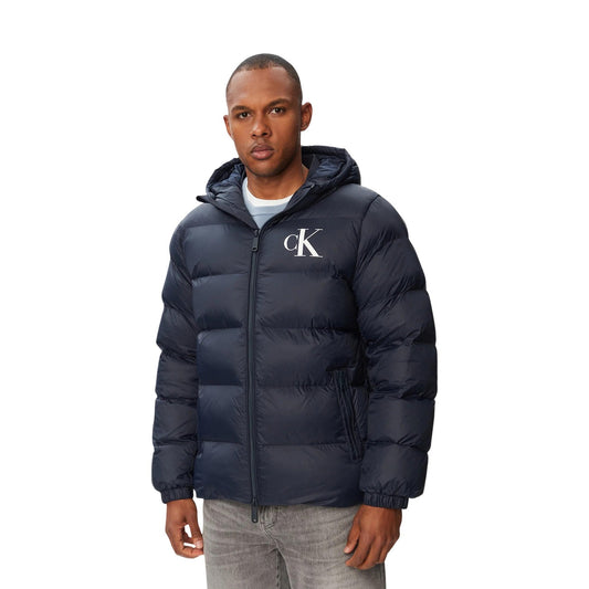 Piumino Calvin Klein uomo blu LV04RG513G. Giambotto pesante invernale in ecopiuma e nylon riciclato con logo CK, cappuccio, tasche con cerniera e vestibilità regolare normal fit.