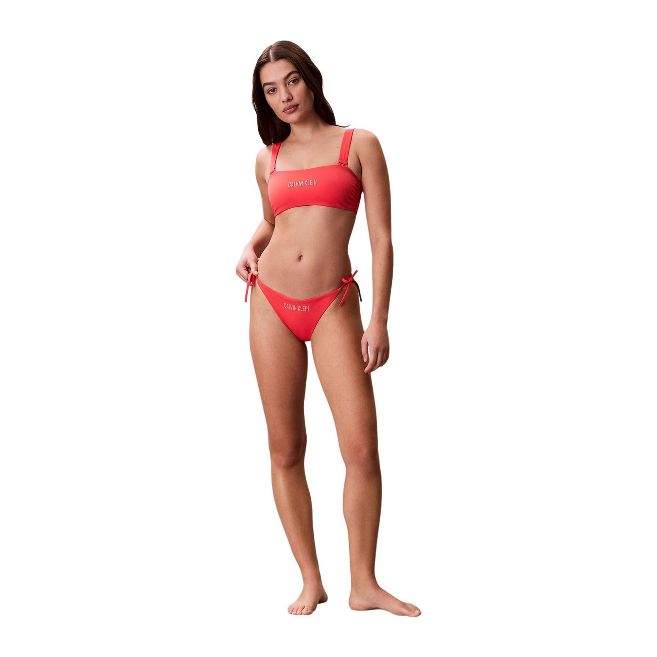 Slip Bikini CK Intense Power arancione/rosso; Side Tie. Tessuto Lycra XTRA LIFE®, vita media, chiusura con lacci laterali. Interamente foderato, asciugatura rapida, logo frontale a contrasto.