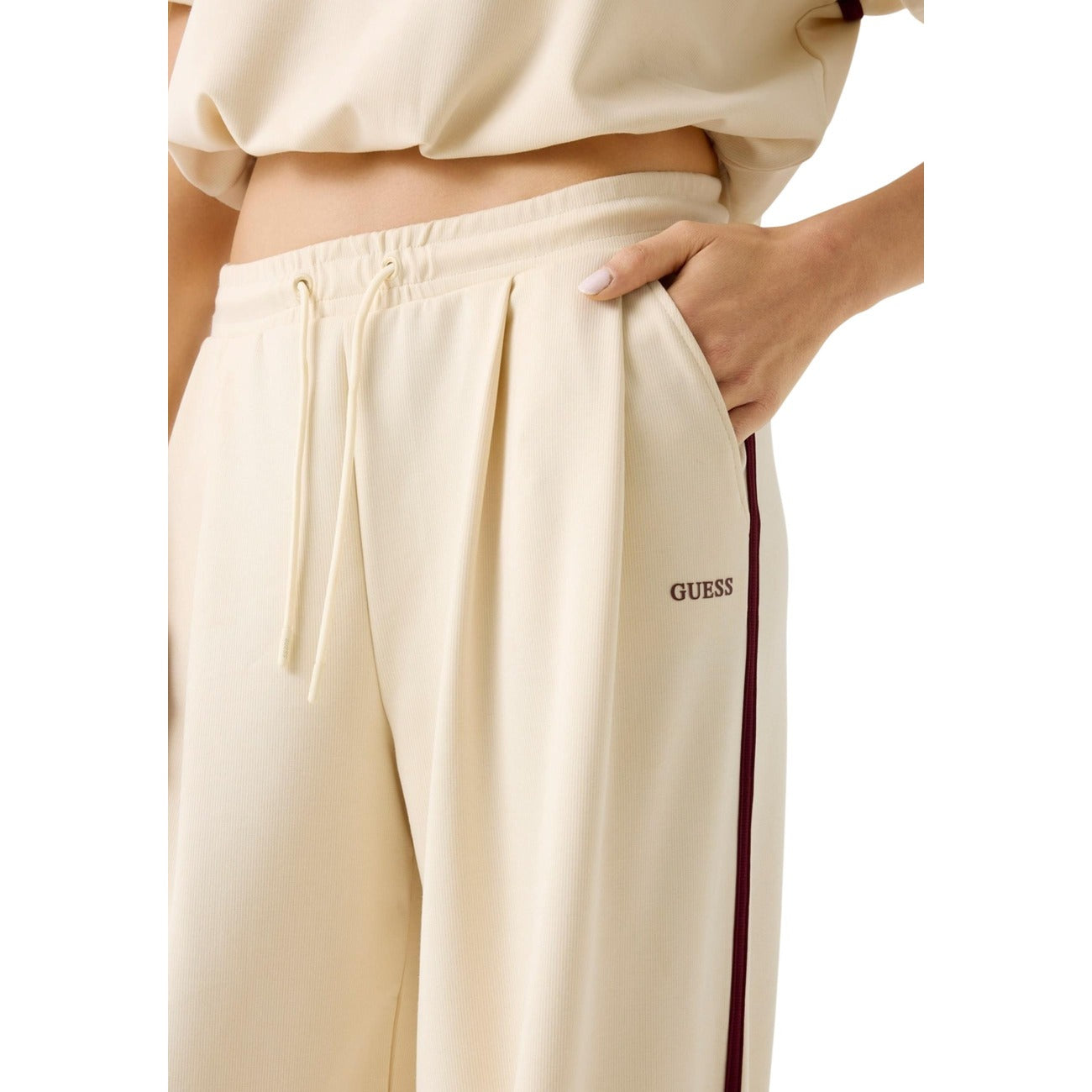 Guess Jasmine Wide Leg Pant; tessuto tecnico stretch (Modal/Lyocell), vita regolabile con coulisse, gamba larga. Comfort premium e stile active-chic. Dettaglio tasca con logo 
