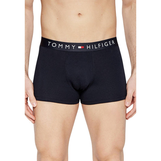 Pack 3 Boxer Trunk Tommy Hilfiger; Nero. 95% Cotone Organico e 5% Elastam. Fascia elastica con logo iconico, vestibilità aderente, tessuto stretch ecosostenibile. Supporto e traspirabilità premium. Indossato da modello 