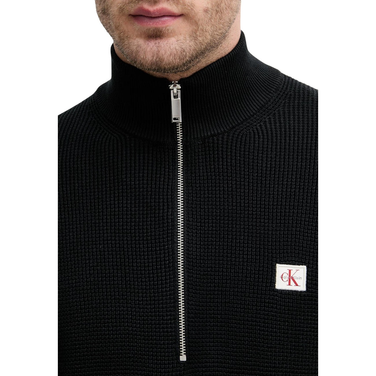 Maglione Nero con Zip Calvin Klein Jeans; 100% Cotone Pettinato. Lavorazione a nido d'ape, stemma monogramma, vestibilità comoda. Caldo, traspirante e versatile. Dettaglio cerniera 