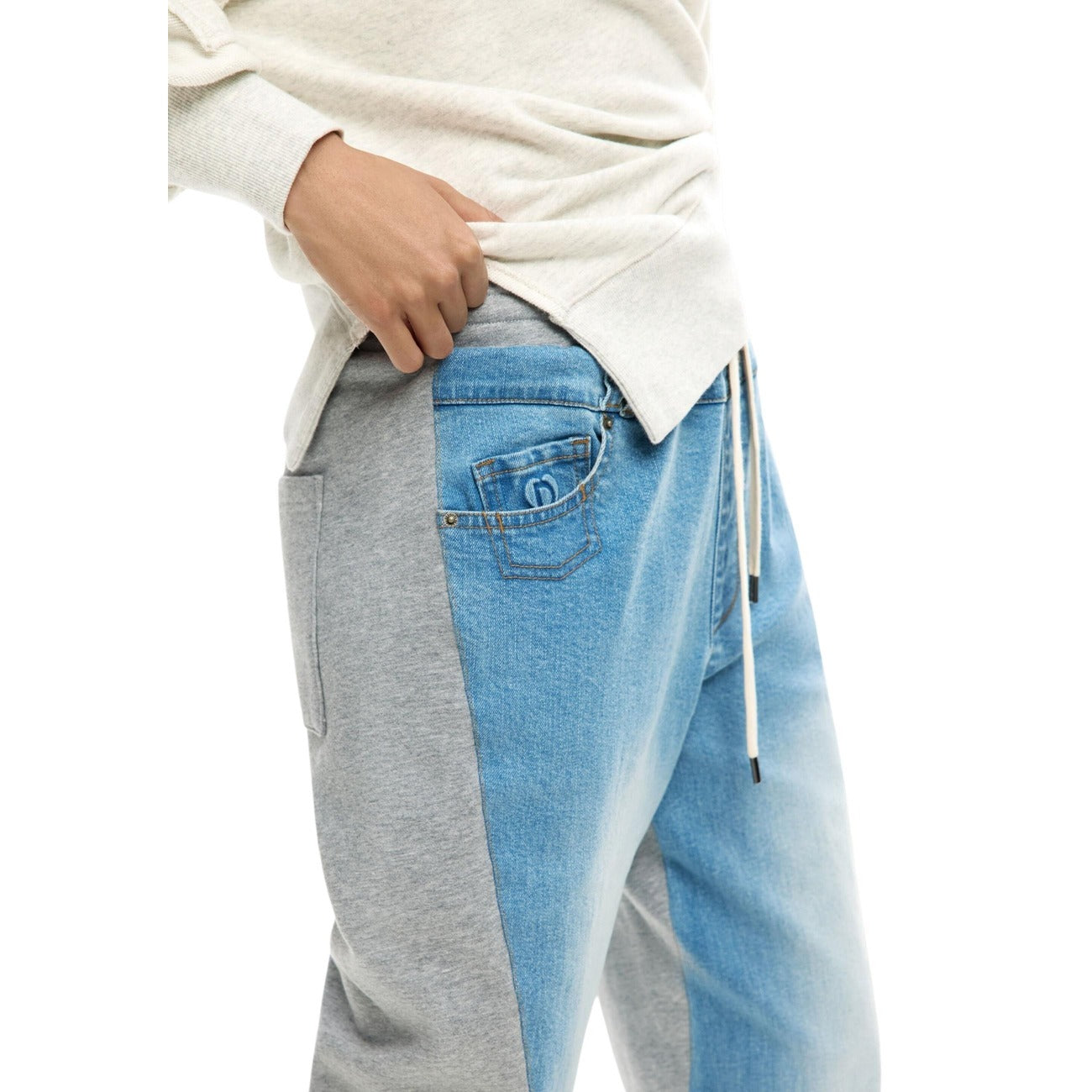 Pantaloni jogger in denim con elastico in vita, realizzati in due materiali a contrasto di colore. Vista laterale 
