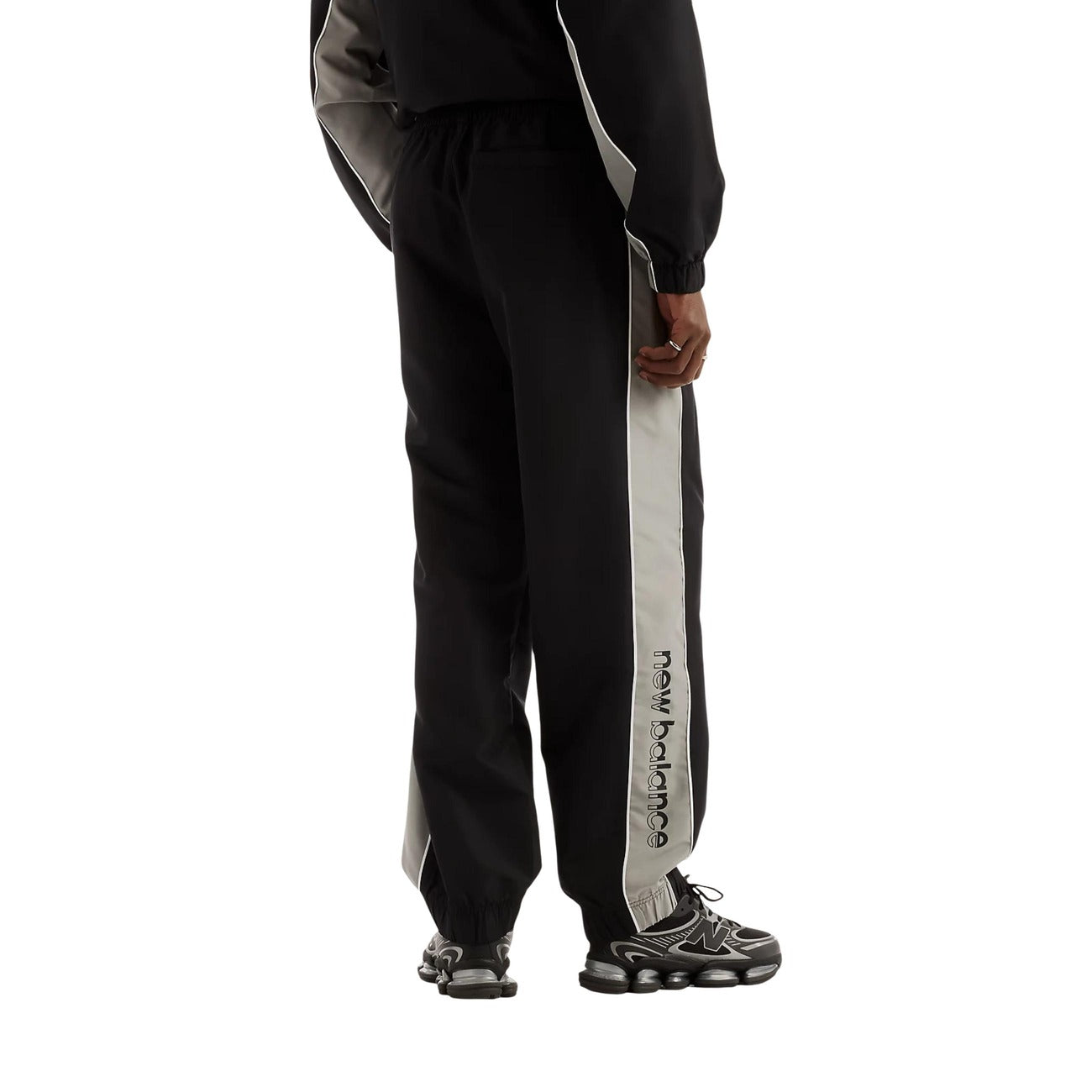 Pantaloni sportivi New Balance neri uomo MB62A8LTBK. Pantaloni tuta da uomo neri in poliestere con banda laterale a contrasto, fondo con elastico alla caviglia, tasche con cerniera e logo stampato, pantaloni casual da ginnastica 4 stagioni.