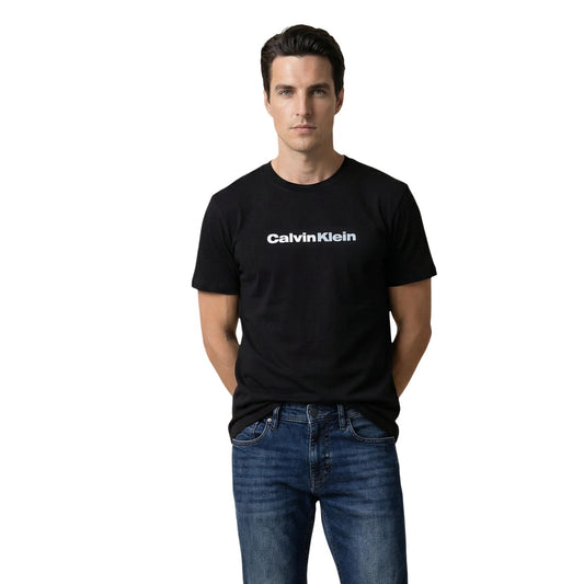 T-shirt Calvin Klein Jeans; 100% Cotone. Vestibilità regolare, logo frontale a contrasto, maniche corte. Maglia uomo traspirante, resistente e iconica per la stagione PE26. Colore nero vista frontale 