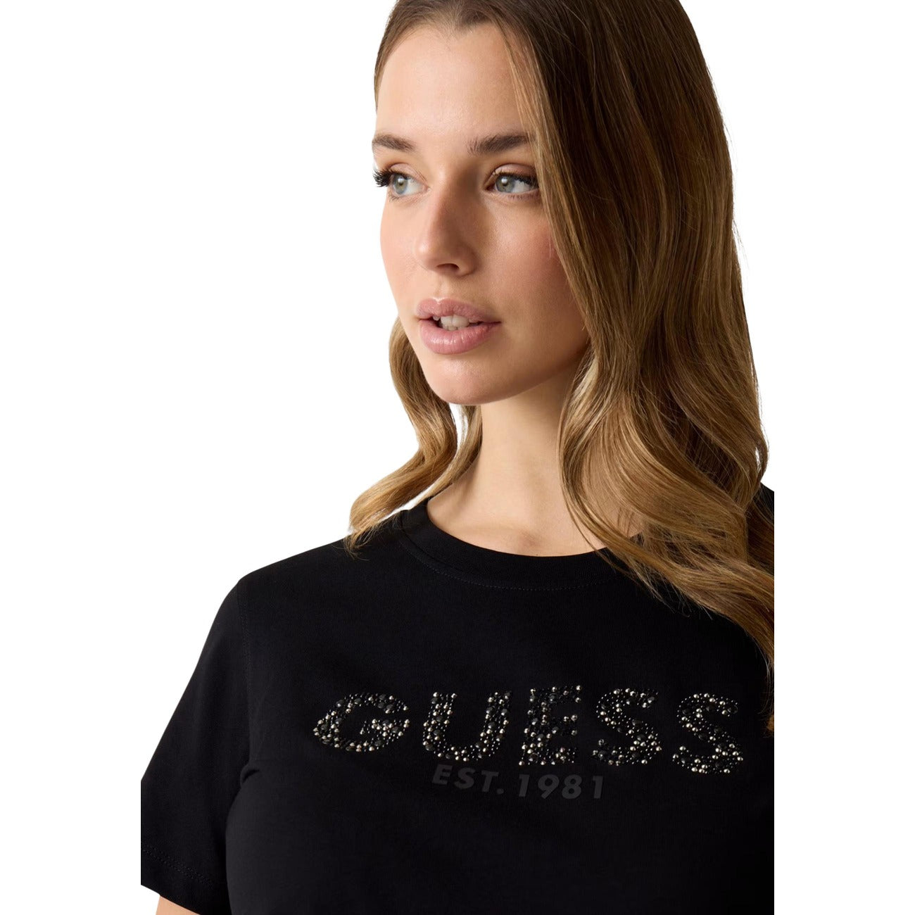 T-shirt Guess Nera con Strass; 100% Cotone. Logo script luminoso, maniche corte, scollo tondo. Vestibilità regolare, stile glamour-casual. Ideale per ogni occasione. Vista frontale Dettaglio 