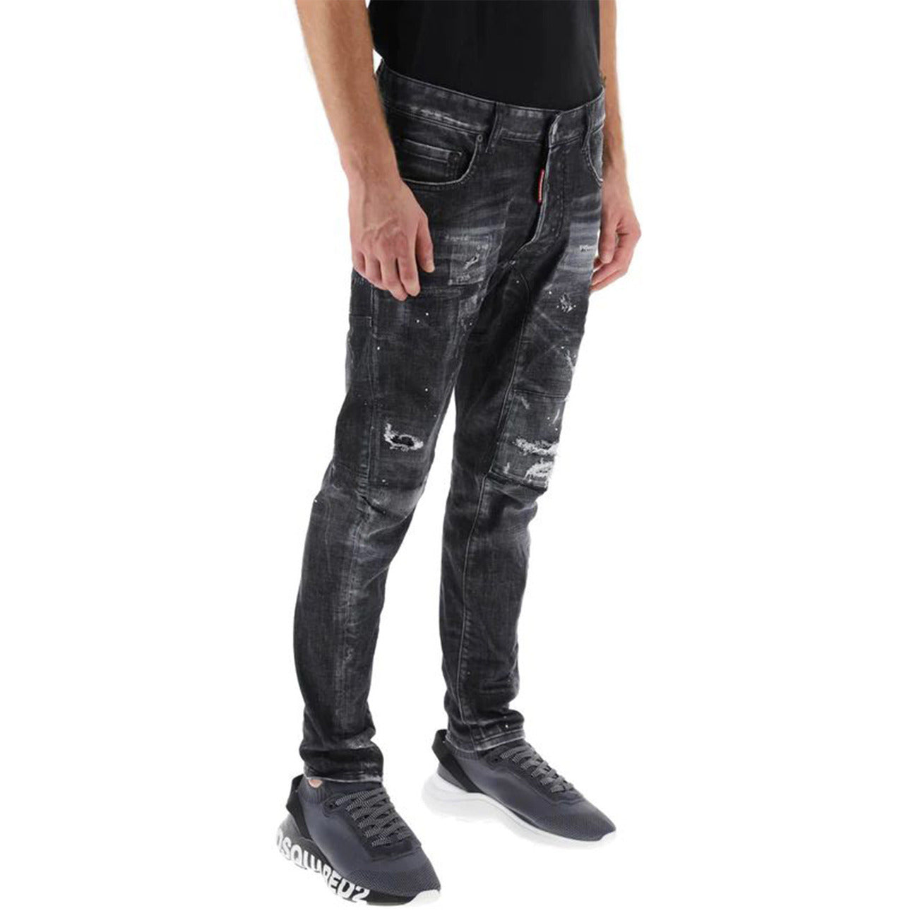 Jeans Dsquared2 Skater Fit; Black Wash Distressed. Dettagli con vernice, rammendi e patch rossa iconica. Taglio affusolato, denim di alta gamma, stile urban-premium. Vista laterale frontale 