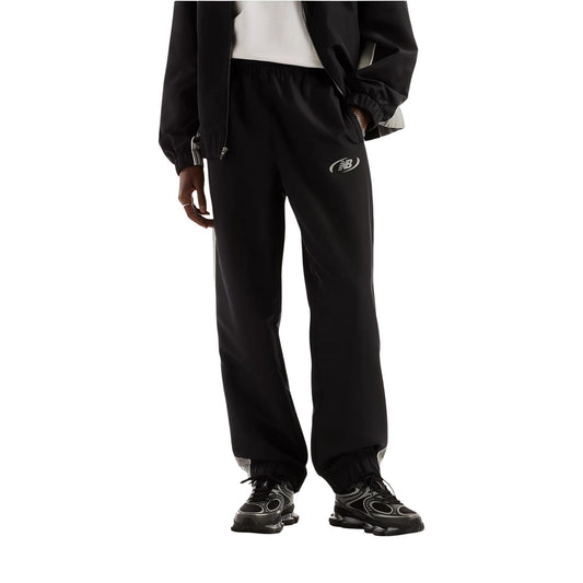 Pantaloni sportivi New Balance neri uomo MB62A8LTBK. Pantaloni tuta da uomo neri in poliestere con banda laterale a contrasto, fondo con elastico alla caviglia, tasche con cerniera e logo stampato, pantaloni casual da ginnastica 4 stagioni.