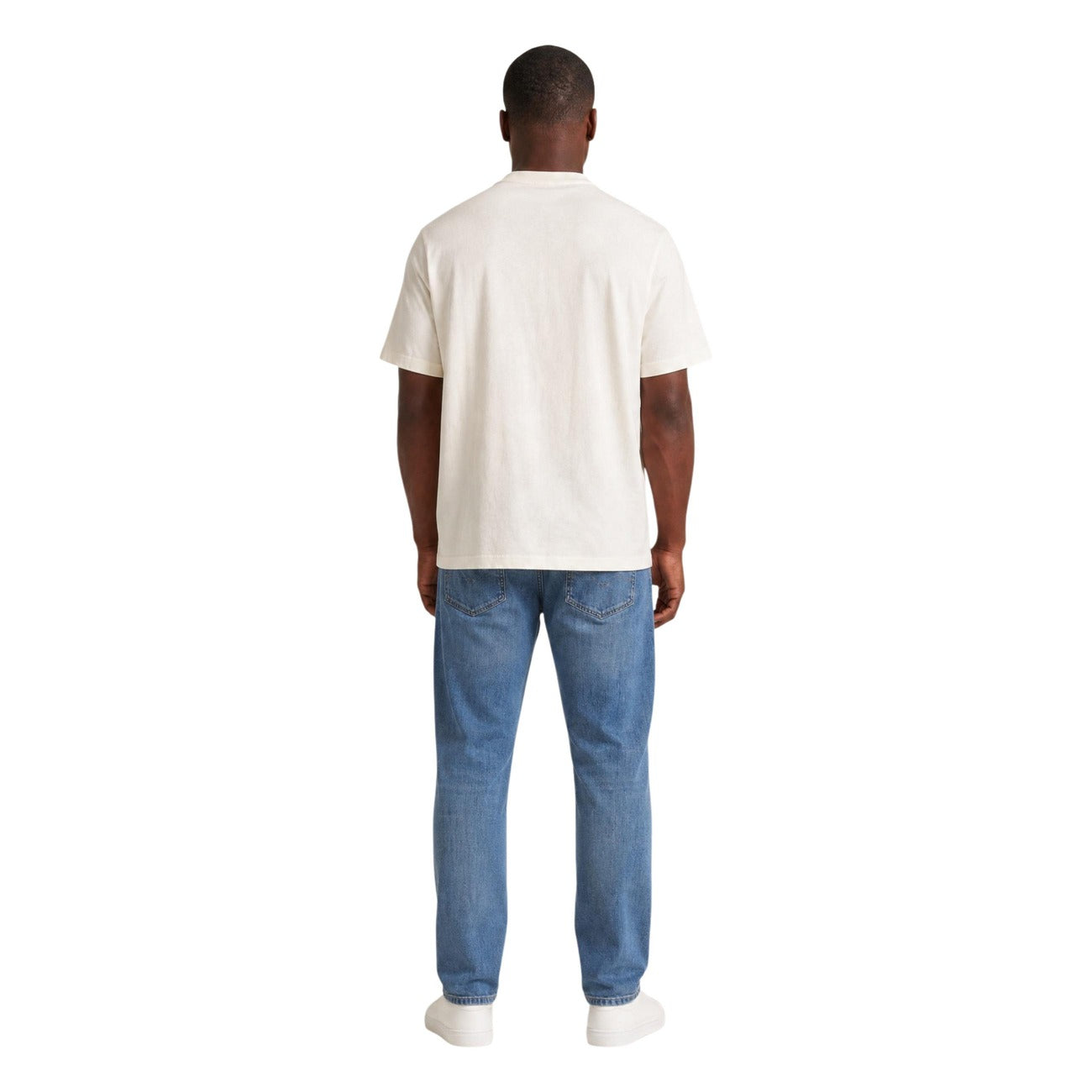 T-shirt Bianca Tommy Jeans; Maxi Logo frontale. 100% Cotone Rigenerato. Regular fit, girocollo, maniche corte. Fresca, iconica ed eco-friendly. Posteriore figura intera 