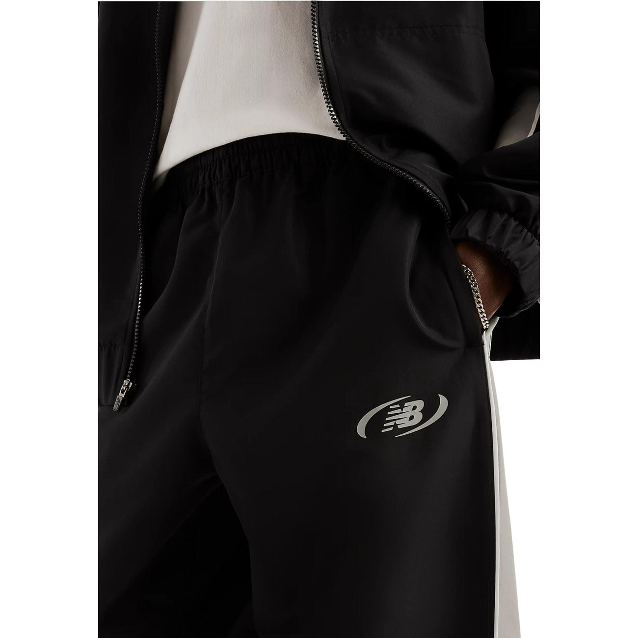 Pantaloni sportivi New Balance neri uomo MB62A8LTBK. Pantaloni tuta da uomo neri in poliestere con banda laterale a contrasto, fondo con elastico alla caviglia, tasche con cerniera e logo stampato, pantaloni casual da ginnastica 4 stagioni.
