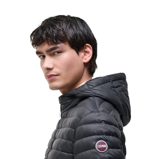 Piumino uomo Colmar Originals nero 100 grammi 1245 8VX. Giacca leggera da uomo nera in tessuto opaco idrorepellente con interno a contrasto, cappuccio fisso, bottone al collo, zip doppio cursore e bordo elastico logato, giubbotto primaverile casual sportivo.