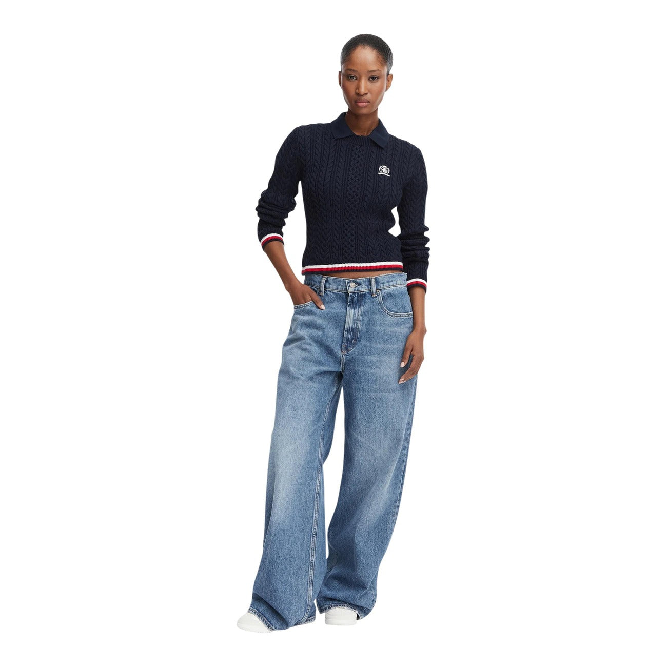 Maglione Polo Donna Blu Tommy Hilfiger Jeans; Maglia pesante cropped a trecce in cotone rigenerato. Colletto stile polo, maniche lunghe, dettagli tricolore sui bordi a coste e logo ricamato. Stile casual raffinato. Figura intera frontale 