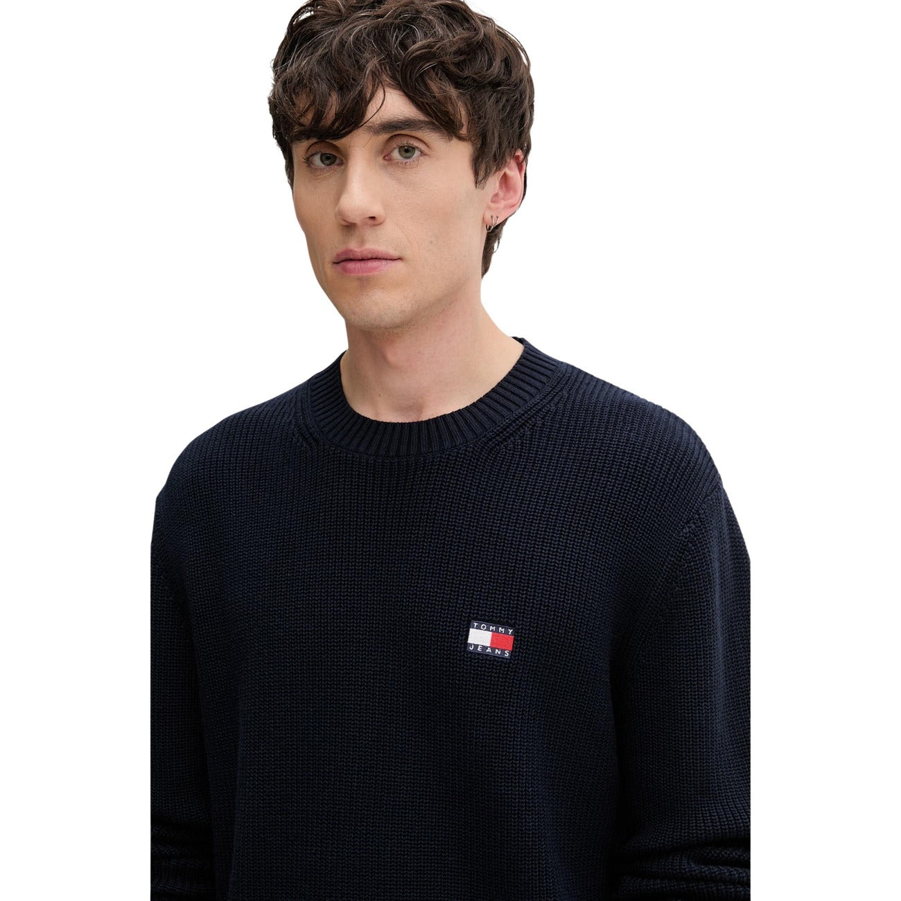Maglione Tommy Jeans uomo blu DM0DM20923. Pullover a girocollo in cotone sostenibile con lavorazione a maglia spessa, maniche lunghe, bordi a costine e logo classico applicato sul petto.