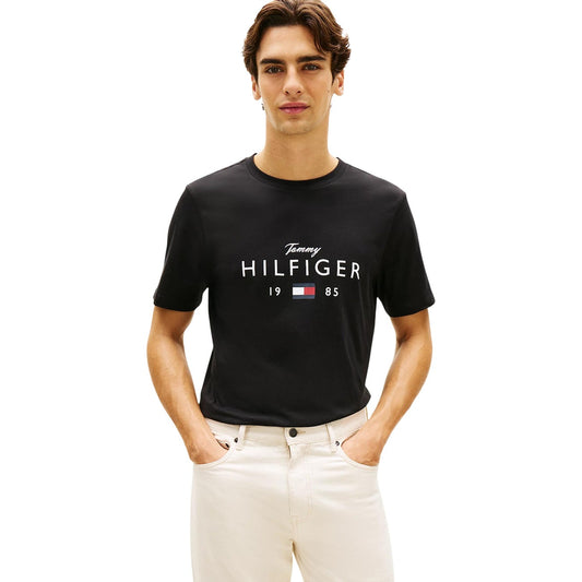 T-shirt Tommy Hilfiger Nera; 100% Cotone. Maxi logo frontale con Flag, maniche corte, vestibilità regular. Girocollo a costine, tessuto morbido e resistente, stile casual iconico. Vista frontale 