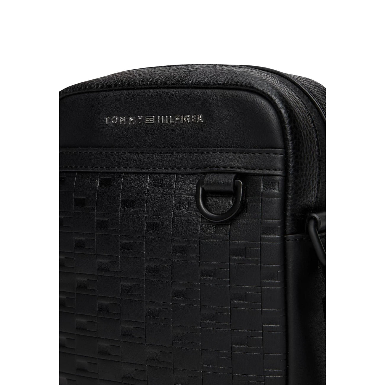 Borsa reporter a tracolla Tommy Hilfiger con mix di texture, motivo a bandierina impresso e logo metallico frontale; dotata di chiusura con zip e anello a D laterale. Vista frontale dettaglio 