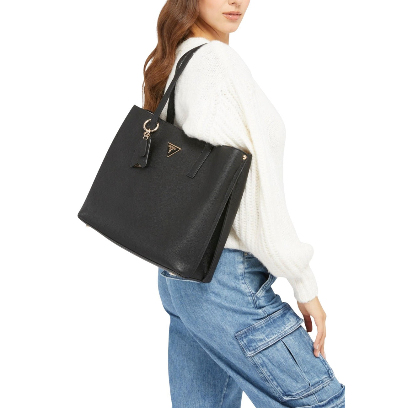 Borsa Guess Meridian II Girlfriend Tote; 100% Poliuretano. Chiusura zip e pressione, dettagli oro, charm logato removibile. Borsa a mano nera capiente e organizzata, collezione Primavera/Estate. Indossata da modella 