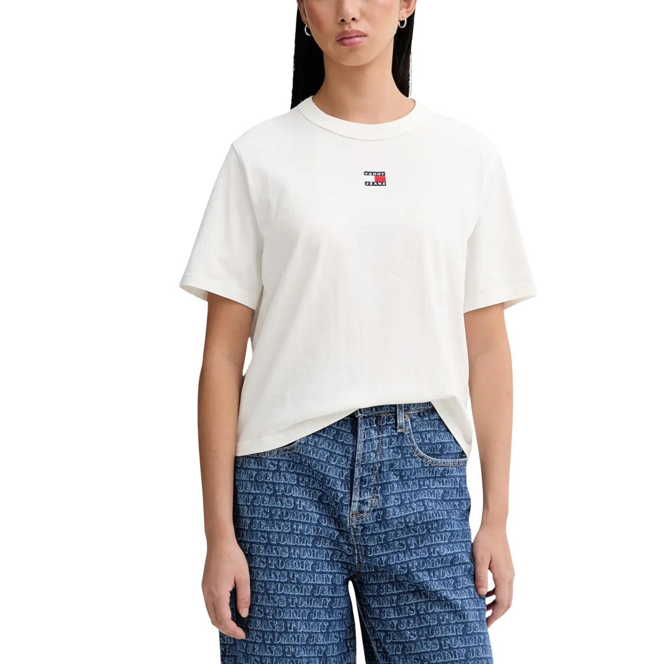 T-shirt Donna Tommy Jeans Boxy Cropped; 100% Cotone. Spalle scese, logo badge sul petto, taglio corto. Maglia donna fresca e di tendenza per la PE26. Colore Bianco 