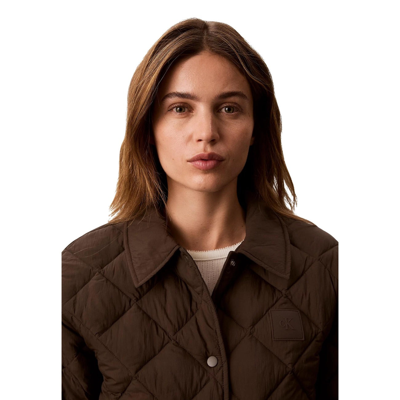 Giacca corta marrone donna Calvin Klein Jeans Dark Coffee trapuntata a rombi. Giacchetto boxy fit impermeabile e antivento con colletto classico, bottoni a pressione, tasche laterali e patch logo Monogram Calvin Klein, abbigliamento donna autunno inverno.