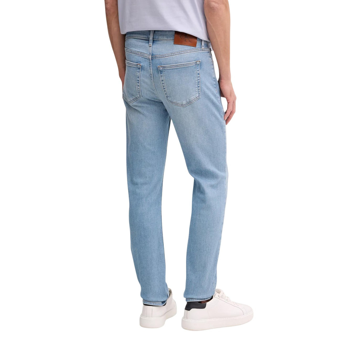Jeans Slim Calvin Klein; Blu. 85% Cotone, 13% Poliestere Riciclato, 2% Elastan. Vita media, 5 tasche, chiusura con cerniera. Vestibilità asciutta e tessuto elasticizzato sostenibile. Posteriore 