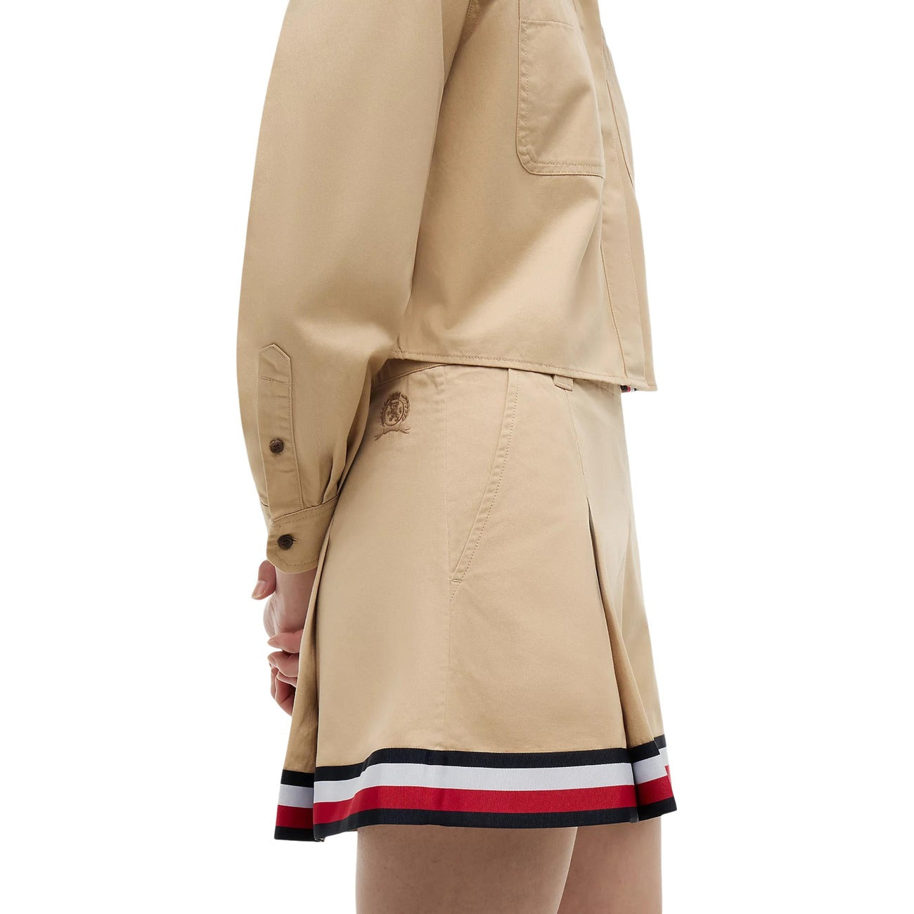 Gonna Tommy Jeans donna Gentle Gold DW0DW22969. Minigonna a pieghe in stile college in 100% cotone biologico, colore oro beige con tasche ad angolo e nastro riga Tommy sul fondo, abbigliamento donna autunno inverno.
