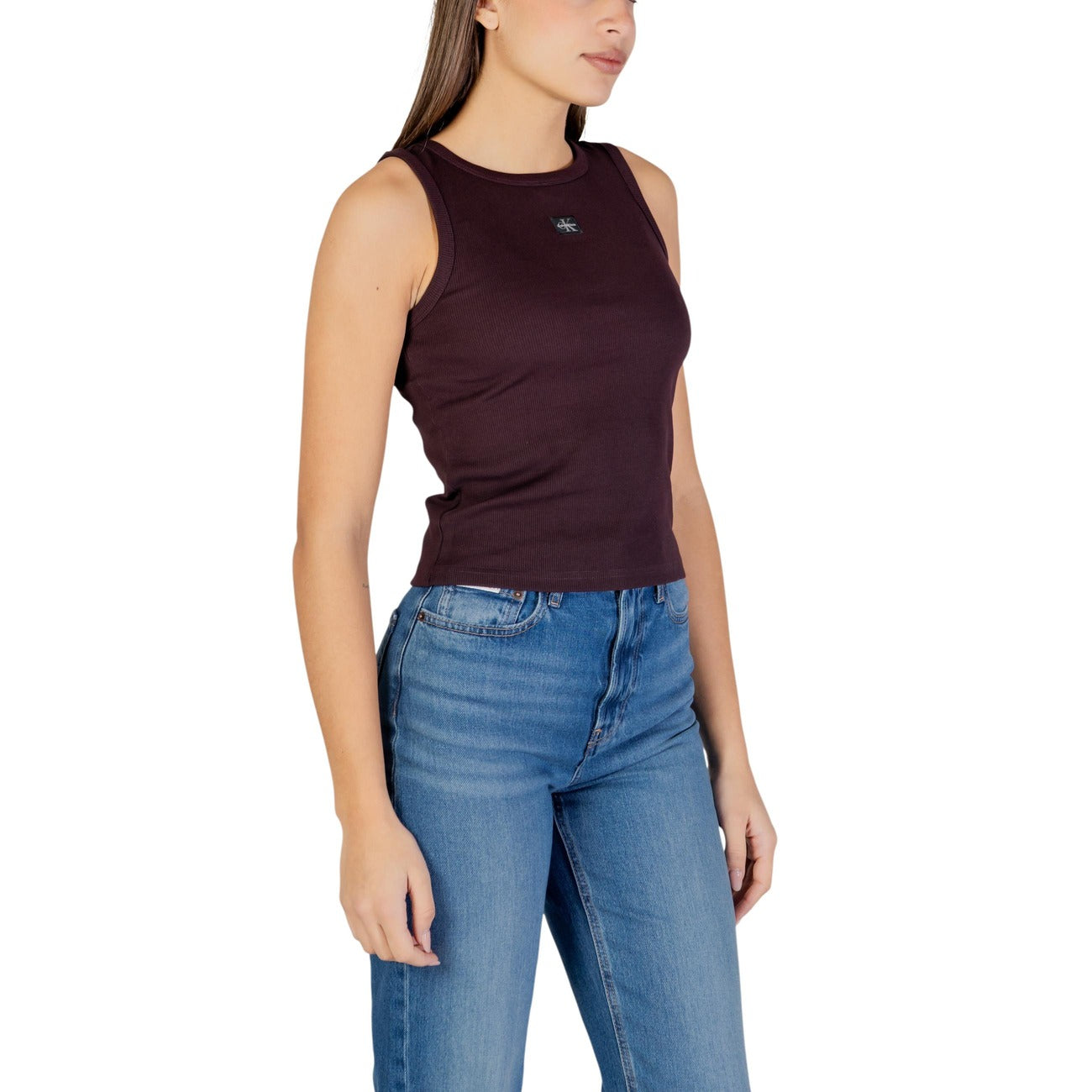 Canotta CK Jeans Woven Label; 95% Cotone, 5% Elastane. Lavorazione a costine 2x2, vestibilità aderente, logo etichetta tessuta. Top donna estivo fresco, elastico e di tendenza. Colore marrone vista laterale