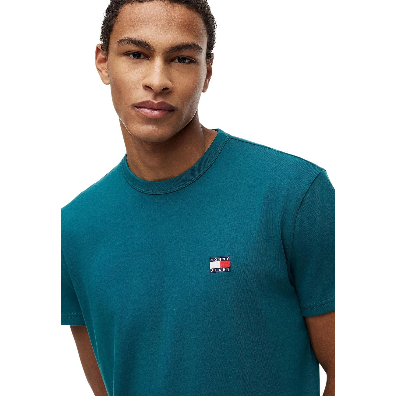 T-shirt Verde Tommy Jeans; Logo Badge Ricamato. 100% Cotone Rigenerato. Regular fit, girocollo classico, ecosostenibile. Il basic premium ideale per ogni outfit.