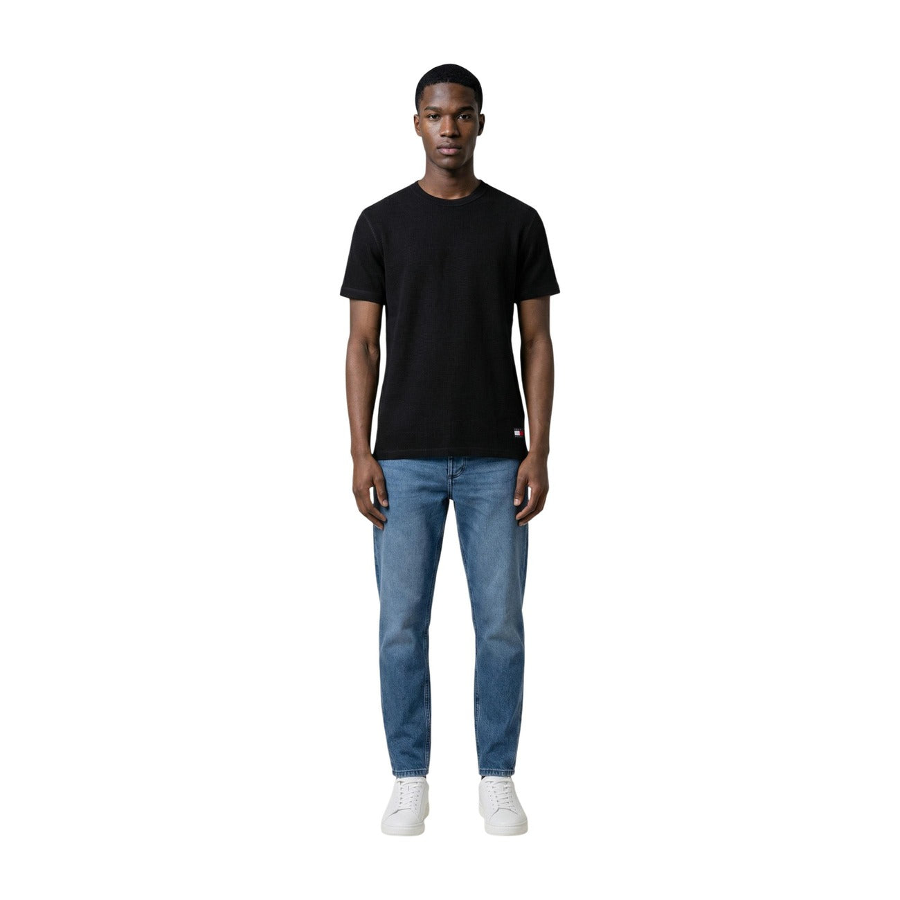 Tommy Hilfiger Jeans T-Shirt nera REGULAR FIT maniche corte Uomo. Realizzata 60% cotone organico e 40% poliestere. Vista frontale Figura intera indossato da modello 