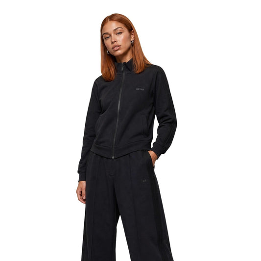 Felpa Nera Donna Guess Active Lyra High Neck; Tessuto elasticizzato in poliestere, modal ed elastam con chiusura full zip e colletto alto. Tasche laterali e logo sul petto, stile sportivo mezza stagione. Vista frontale 