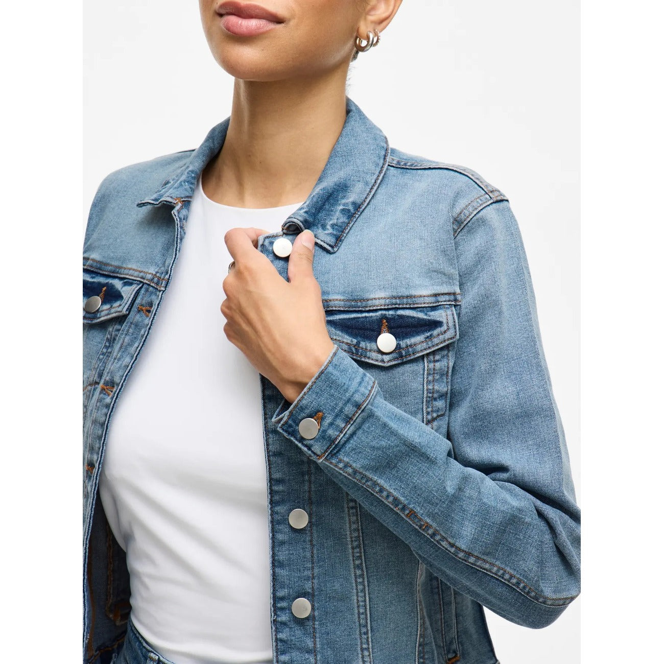 Giacca Denim Donna Azzurra Vila Clothes; Tessuto traspirante in cotone organico e poliestere con chiusura a bottoni. Tasche sul petto e anteriori, colletto classico e maniche lunghe, stile casual primavera-estate.