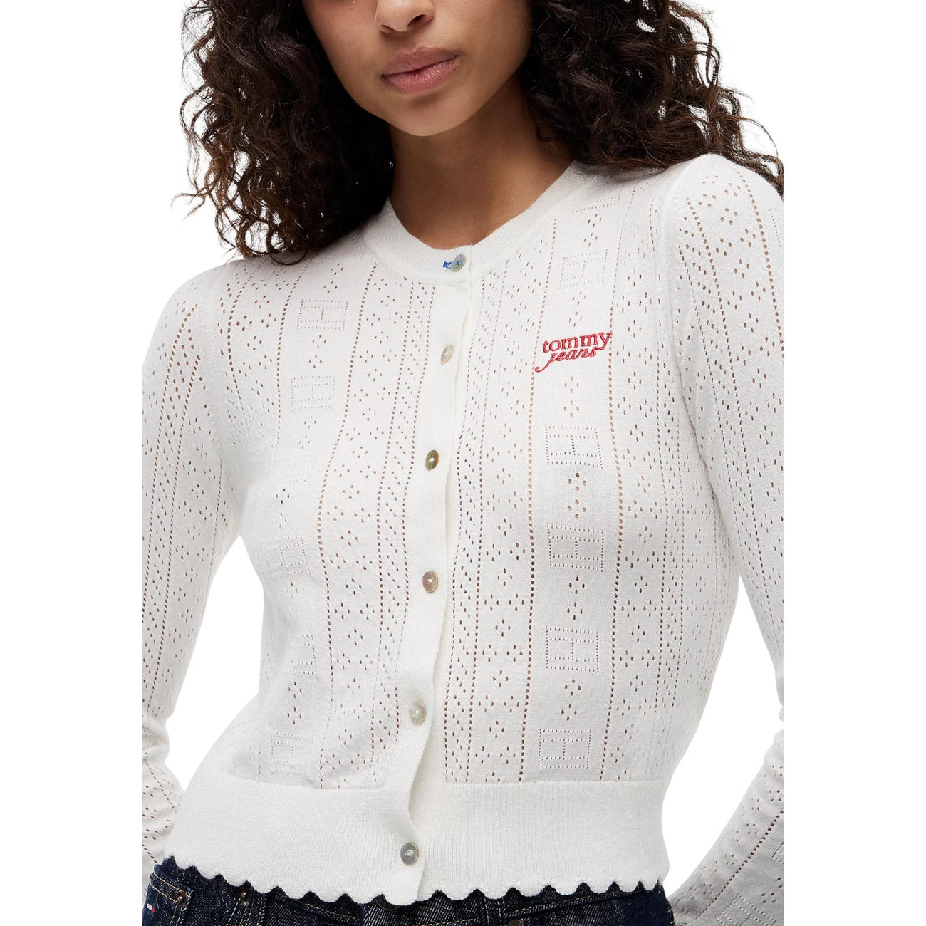 Cardigan Donna Bianco Tommy Hilfiger Jeans; Maglia slim fit traforata a maniche lunghe con bottoni, scollo tondo e motivo pointelle a bandierine. Dettagli smerlati, stile preppy casual e raffinato. Frontale dettaglio 
