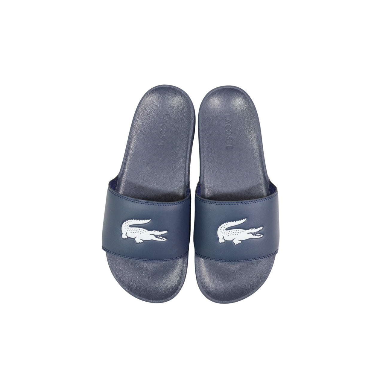 Ciabatte blu a fascia da uomo Lacoste Serve Slide 1.0 con logo del coccodrillo in rilievo sulla fascia ampia e suola ergonomica coordinata. Vista dall’alto 