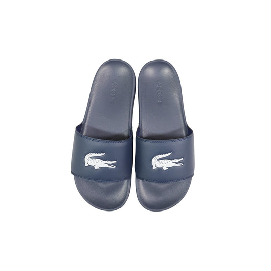 Ciabatte blu a fascia da uomo Lacoste Serve Slide 1.0 con logo del coccodrillo in rilievo sulla fascia ampia e suola ergonomica coordinata. Vista dall’alto 