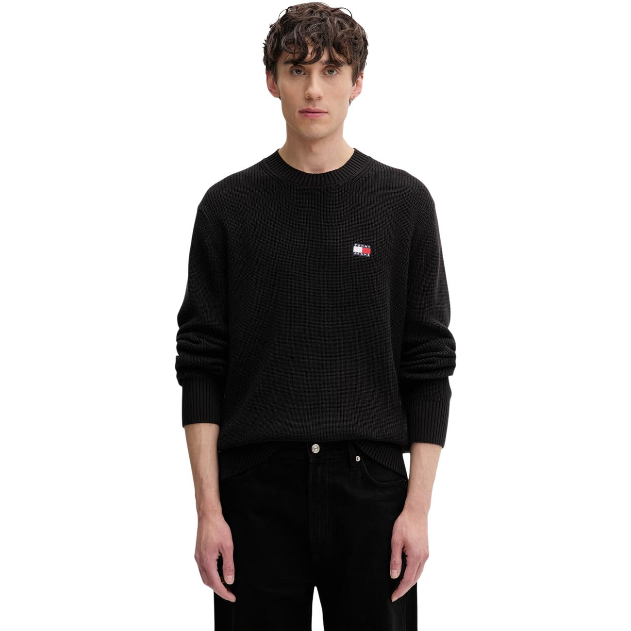 Maglione Tommy Jeans uomo nero DM0DM20923. Pullover a girocollo in cotone sostenibile con lavorazione a maglia spessa, maniche lunghe, bordi a costine e logo classico applicato sul petto.